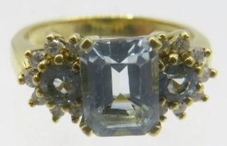 An 18ct yellow gold ring set with centre emerald cut aquamarine with two either side & round