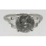 An 18ct white gold old cut solitaire diamond ring set with baguette diamond shoulders, size M.