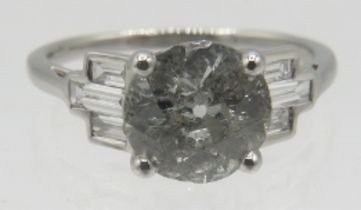 An 18ct white gold old cut solitaire diamond ring set with baguette diamond shoulders, size M.