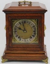 An English oak and gilt brass mounted mantle clock, late 19th/early 20th century. Dial with Roman