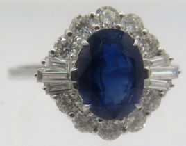 An 18ct white gold ring set with oval mix cut sapphire surrounded by brilliant cut & baguette