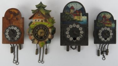 Four vintage miniature Black Forest clocks. Two depicting Chateau Chillon, one inlay decorated and