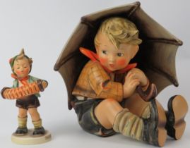 A large Hummel ‘Umbrella Boy’ and ‘Accordion Boy’ ceramic figurine. Numbered 152A and 185. Factory