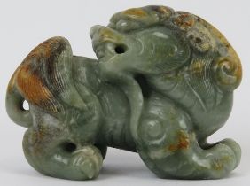 A Chinese celadon and russet jade Buddhistic lion, 20th century. 7 cm length. Provenance: Private