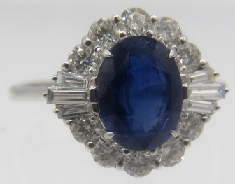 An 18ct white gold ring set with oval mix cut sapphire surrounded by brilliant cut & baguette - Image 2 of 2