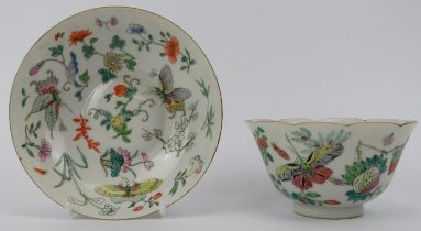 A Chinese famille rose cup and saucer, early 19th century. Both decorated with butterflies amongst