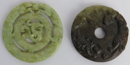 Two Chinese celadon and russet jade carved discs, 20th century. One carved as a bi disc with