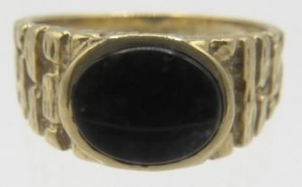 A 9ct yellow gold signet ring set with centre black stone, size W. Approx weight 6.3 grams.