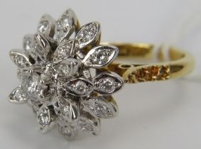 An 18ct yellow & white gold diamond cluster ring. The centre diamond approx 0.25cts with each