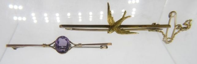 A 9ct gold swallow bar brooch with safety chain and a 9ct gold amethyst set bar brooch. Approx