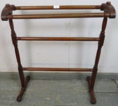 A late 19th century mahogany double towel rail, on turned and block supports with splayed feet.