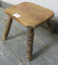 A 19th century sycamore milking stool of abundant character, on bobbin turned canted supports. H19cm