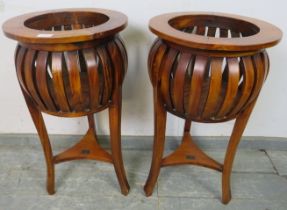 A pair of period style hardwood basket jardinières, on curved tripod supports with braced