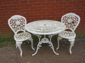 Two antique cast iron garden chairs painted white, together with an associated aluminium circular