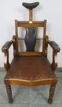 A turn of the century walnut barber’s chair, having adjustable backrest and headrest, both with