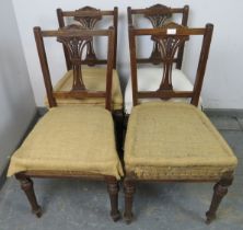 A set of four Edwardian mahogany dining chairs, with carved and pierced backsplats and reeded