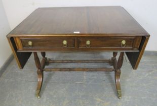 A vintage mahogany sofa table in the Regency taste, having short cock-beaded drawers with gilt brass