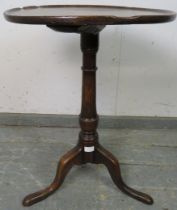 An 18th century oak circular wine table of good colour and patina, the dished top on a tapering