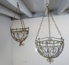 A vintage pair of graduated wrought iron hanging baskets with ball finials and scrolled