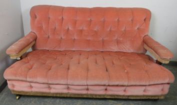 A Victorian mahogany framed two-seater sofa, re-upholstered in buttoned salmon velvet material, on