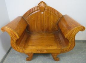 A large Indonesian teak throne chair, having shell carved cornice above scrolled and fluted arms, on