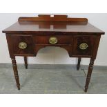 A George IV mahogany lowboy, having shaped rear gallery with turned roundel decoration, housing