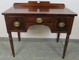 A George IV mahogany lowboy, having shaped rear gallery with turned roundel decoration, housing