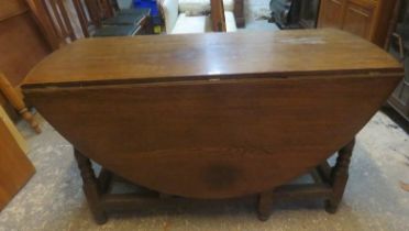 A well made solid oak oval drop leaf gateleg dining table in the 18th century style, raised on