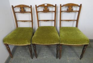A trio of Edwardian rosewood occasional chairs, the pierced backs with marquetry inlay, on turned