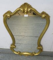 A vintage giltwood wall mirror in the early Georgian taste, within a shaped surround decorated