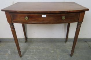 A George IV mahogany bow-fronted hall table, strung with ebony and satinwood, housing one long