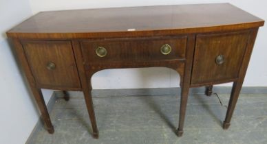 A Regency mahogany bow fronted sideboard, the central drawer flanked by two cupboards, with brass