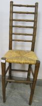 A 19th century faux bamboo ladderback child’s correctional chair, having a rush seat, on tapered