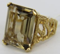 A 9ct yellow gold emerald cut smoky quartz ring with openwork sides, size O, boxed. Approx 20mm x