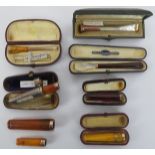 Tobacconalia: A group of eight gold mounted cheroot holders. Seven marked 9ct gold, one marked