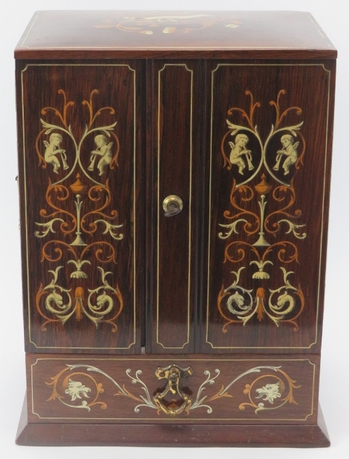 Tobacconalia: An Edwardian rosewood and marquetry inlaid smokers cabinet. Decorated with cherubs,