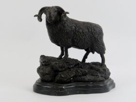 A bronzed metal figure of a ram on a rocky outcrop, 20th century. Supported on a marble base. 21.3