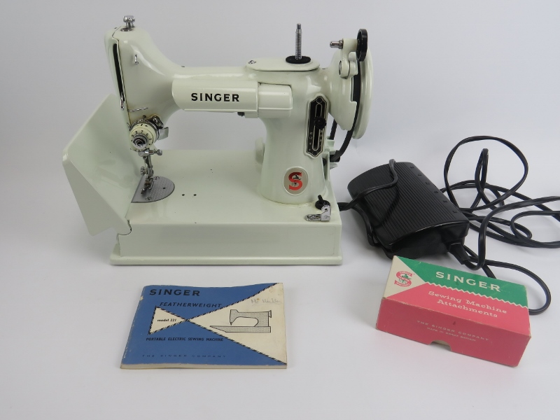 A Singer Featherweight Model 221 portable electric sewing machine. The white Model 221 sewing