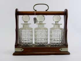 An oak tantalus with three glass decanters, late 19th/early 20th century. 34.7 cm length, 31.5 cm