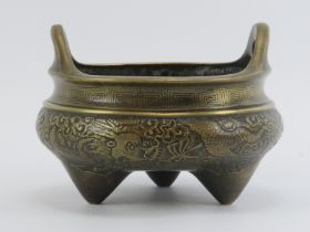 A Chinese bronze bombe censer, 19th century. Decorated with five clawed dragons amongst clouds