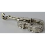 A silver box in the form of a violin with embossed decoration depicting putti in rural scenes.