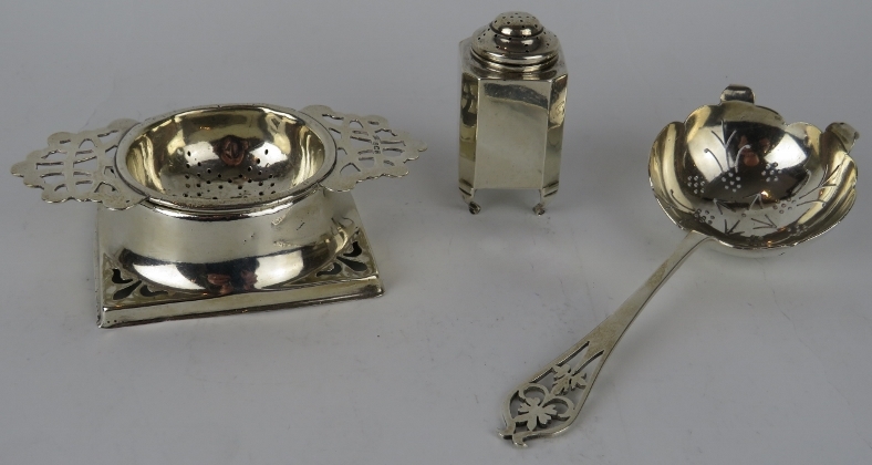 A silver tea strainer and stand, a similar silver tea strainer and an Art Deco pepperette. Various