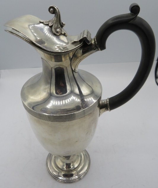 A silver pedestal ewer with ebonised handle, Sheffield 1902. Approx weight 16.5 troy oz/513 grams.