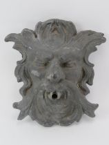 A cast lead Green Man gargoyle. Modelled with a spout protruding from the mouth. 28 cm height.