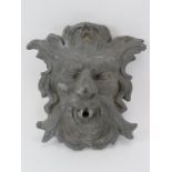 A cast lead Green Man gargoyle. Modelled with a spout protruding from the mouth. 28 cm height.