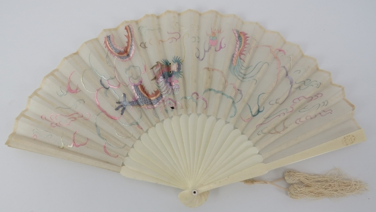 A Chinese silk and carved bone fan, mid 19th century. Embroidered with a dragon amongst clouds in