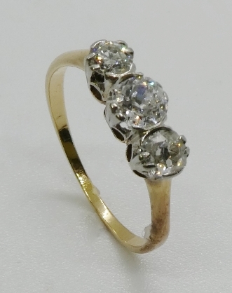 A three stone diamond ring, the graduated three old cut diamonds, claw and part rub-over set, in