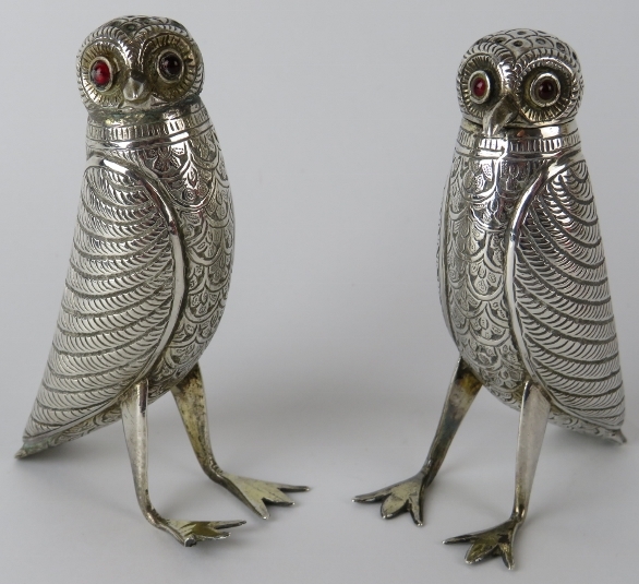 A pair of Indian white metal pepperettes in the form of birds with red glass eyes. Height 9cm. Gross