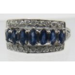 A fine white metal sapphire & diamond ring. Seven marquise cut sapphires, approx 5mm x 3mm in centre