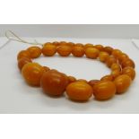 A Butterscotch amber bead necklace, having 35 graduated oval beads, 520mm long, smallest bead 9.